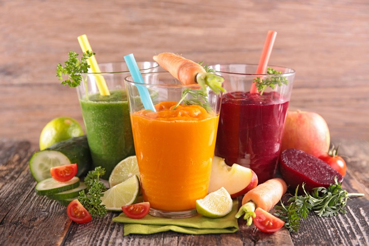 Drei mit Saft gefüllte Gläser, garniert mit Gemüse.